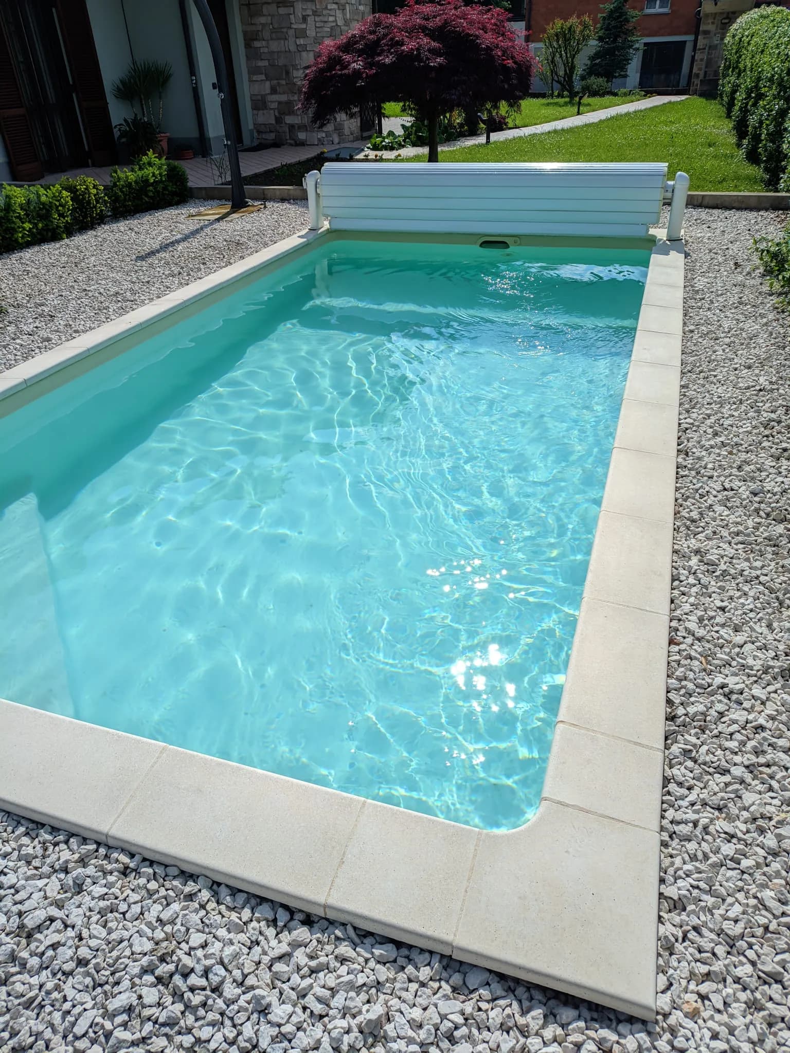 Bordo in ghiaia decorativa con pietra chiara e copertura avvolgibile